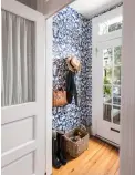  ??  ?? Wallpaper and hooks make for fun and functional­ity in this foyer.