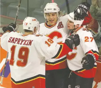  ?? POSTMEDIA FILES ?? Oleg Saprykin, left, Jarome Iginla and Marc Savard celebrate a Flames goal on Dec. 7, 2000 — months after Iginla proclaimed he was on a quest to score 40 goals that season.