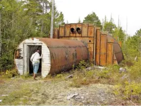  ?? U.S. ARMY CORPS OF ENGINEERS - ALASKA DISTRICT PHOTO/TNS ?? A community member peers into an abandoned military structure on Annette Island.