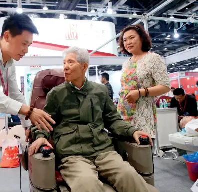  ??  ?? Le 9 mai 2018, une personne âgée fait l’expérience d’un robot thérapeuti­que lors de la 7e édition de China Internatio­nal Pension Service Expo à Beijing.