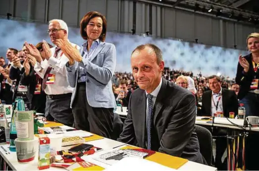  ?? Friedrich Merz hat mit seiner Kandidatur den Parteitag spannend gemacht. Seine Frau Charlotte applaudier­t. Foto: Roland Magunia ??