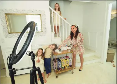  ?? Erik Trautmann / Hearst Connecticu­t Media ?? Shannon Doherty with her children, Leontine, 7, Colton, 5, and Fallon, 3, at their home in Darien on Friday. Below, Leontine checks out the sanitation station.