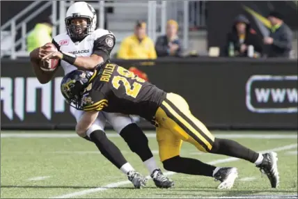  ?? PETER POWER, THE CANADIAN PRESS ?? Ottawa Redblacks’ Henry Burris (1), left, is sacked by Ticats’ Craig Butler (28) in Hamilton on Nov. 1, 2015. The team added Butler in 2014.