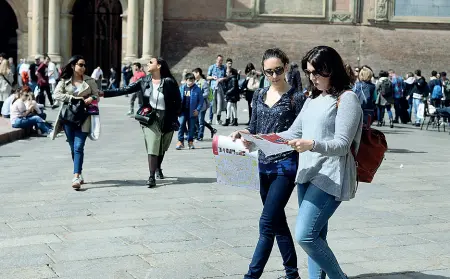  ??  ?? Le scelte Cartelli e messaggi social per comunicare la decisione di restare aperti o meno alla propria clientela.
In alto, l’immagine di una piazza Maggiore popolata da turisti