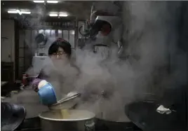  ?? Felipe Dana ?? The Associated Press A woman cooks at a restaurant Monday in Gangneung, South Korea. The local food, while some of the world’s tastiest, can also conflict with some of the athletes’ strict dietary needs during the competitio­n.