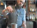  ??  ?? Head bartender Phil Clark of Blue Hound adds cinnamon syrup to a shaker.