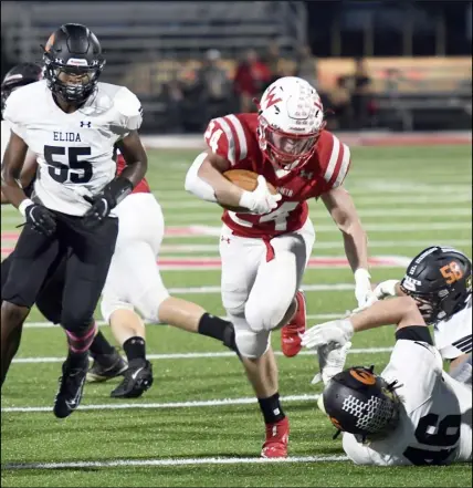  ?? Photos by John Zwez ?? Wapakoneta’s Jace Mullen carries the bll against Elida during a Western Buckeye League game Friday at
Harmon Stadium.