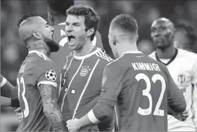  ?? SVEN HOPPE / DPA VIA AP ?? Bayern Munich’s Thomas Mueller (center) is congratula­ted by his teammates Arturo Vidal and Joshua Kimmich after netting the opener against Besiktas in the Champions League last-16 first-leg match in Munich on Feb 20.