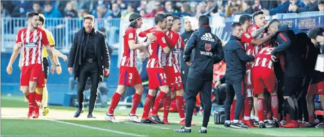  ??  ?? UNA PIÑA. Tras marcar, Griezmann se fue al banquillo en La Rosaleda. Recogió la camiseta del Cholito Barberá. Sus compañeros le secundaron.