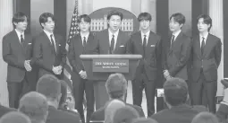  ?? EVAN VUCCI/AP ?? BTS member RM, center, speaks at the White House on Tuesday. Accompanyi­ng him are the band’s other members V, from left, Jungkook, Jimin, Jin, J-hope and Suga.