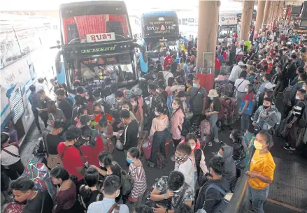  ?? NUTTHAWAT WICHEANBUT ?? Travellers wait to board their buses at the Mor Chit terminal in Bangkok on Sunday. Migrant workers from Thailand’s neighbouri­ng countries are among those reported to have returned home over the weekend.