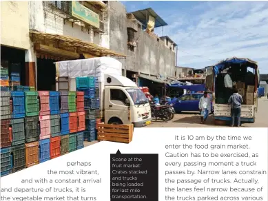  ??  ?? Scene at the fruit market: Crates stacked and trucks being loaded for last mile transporta­tion.