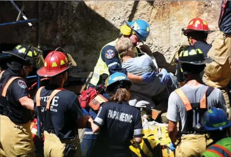  ??  ?? A paramedic comforts a 64-year-old man trapped under a concrete slab at a Carlisle-area dam on Thursday.