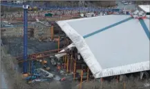  ?? The Associated Press ?? PAUSED PRODUCTION: KeyArena is shown as viewed March 26 from the Space Needle in Seattle with renovation constructi­on temporaril­y halted due to the outbreak of the coronaviru­s. The pandemic has created questions of scheduling and worker health as eight stadiums or arenas are under constructi­on or about to break ground in the five major profession­al sports leagues in North America. Constructi­on on the home of the WNBA Seattle Storm and Seattle’s expansion NHL team — which is scheduled to begin play in the 2021-22 season — was allowed to resume a few days later with an urgency associated with the roof, which weighs more than 40 million pounds and is currently resting mostly on temporary supports.