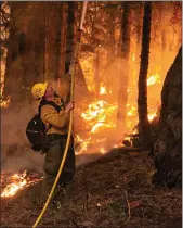  ?? Jason Armond
/ Los Angelestim­es /TNS ?? A firefighte­r works a control burn to head off a spot fire that started on a ridge behind a business on Highway 50 on Saturday in Strawberry, El Dorado County. Firefighte­rs continue to tackle the Caldor fire as it creeps closer to South Laketahoe.