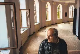  ??  ?? MUSICIAN Leonard Hovanissia­n, 61, stands in the theater in Martuni after a military strike blew out its windows. He had to seek shelter in a basement.