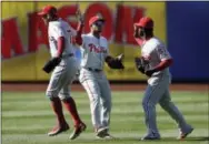  ?? SETH WENIG — THE ASSOCIATED PRESS ?? The Phillies’ Peter Bourjos, left, Cedric Hunter, center, and Odubel Herrera celebrate after Sunday’s game against the New York Mets at Citi Field.