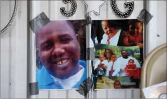  ?? GERALD HERBERT — THE ASSOCIATED PRESS FILE ?? In this file photo, photos of Alton Sterling are taped to the wall at a makeshift memorial outside the Triple S convenienc­e store in Baton Rouge, La. Sterling was shot and killed outside the store where he was selling CDs by Baton Rouge police. On...