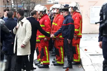  ??  ?? Macron shakes hand with a firefighte­r as he visits firefighte­rs and riot police officers the day after a demonstrat­ion, in Paris. — Reuters photo