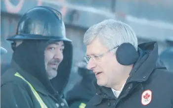  ?? Jonathan Hayward/The Canadian Press ?? Prime Minister Stephen Harper talks to workers in Inuvik, N.W.T., Wednesday as he tours the site of an all-weather road that will stretch 140 kilometres to Canada’s Arctic coast.