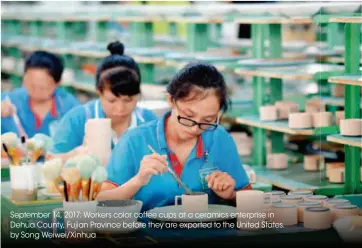  ??  ?? September 14, 2017: Workers color coffee cups at a ceramics enterprise in Dehua County, Fujian Province before they are exported to the United States. by Song Weiwei/xinhua June 2, 2017: Workers on a production line of Lovol Heavy Industry Co., Ltd. in...