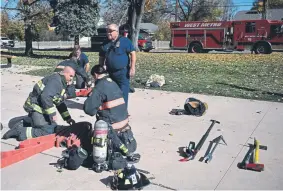  ?? Joe Amon, The Denver Post ?? Todd Rosenberge­r, center, captain of the West Metro Fire and Rescue’s Engine 16, watches firefighte­rs as they secure gear during training at Highland West Community Senior Citizens Apartments on Friday in Wheat Ridge.