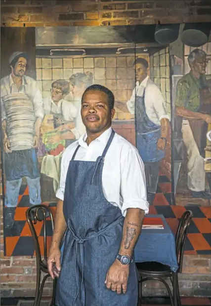  ?? Andrew Rush/Post-Gazette ?? Grill master Courtney McFarlane in front of the mural at Tessaro’s in Bloomfield that features him and other members of the restaurant family. To see video accompanyi­ng this story, visit post-gazette.com