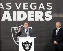  ?? STEVE MARCUS — LAS VEGAS SUN ?? Las Vegas Raiders owner Mark Davis, center, speaks during a news conference, officially renaming the Oakland Raiders to the Las Vegas Raiders, in front of Allegiant Stadium in Las Vegas on Wednesday. Raiders president Marc Badain listens at right.