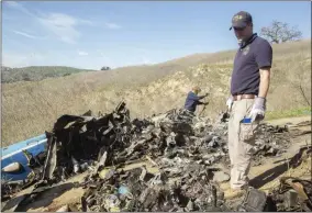  ?? JAMES ANDERSON ?? In this Jan. 27, 2020, file photo, NTSB investigat­ors Adam Huray, right, and Carol Hogan examine wreckage as part of the NTSB’s investigat­ion of a helicopter crash near Calabasas, Calif.