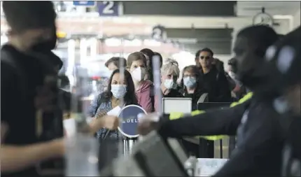  ?? Gary Coronado Los Angeles Times ?? PASSENGERS TRAVEL through Terminal 2 at Los Angeles Internatio­nal Airport on Tuesday, the day after a federal judge voided the Biden administra­tion’s mask mandate for planes, trains, buses and transporta­tion hubs.