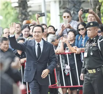  ??  ?? Somchai (centre) waves to supporters as he arrives at the Supreme Court in Bangkok. — AFP photo