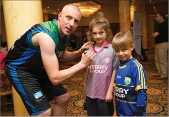  ??  ?? Kieran Donaghy of Garvey’s Tralee Warriors Basketball Team sign’s Lil Mae Bowlers jersey as her brother look on Shea Bowler at the Garvey’s Tralee Warriors press evening in the Brandon Hotel,Tralee