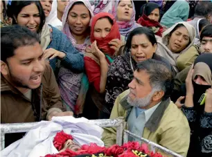  ?? AP ?? People mourn the death of a man killed in the bomb blast during a funeral in Lahore on Tuesday. —