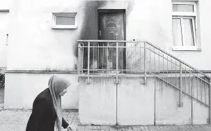  ?? — Gambar AFP ?? KESAN MASIH TINGGAL: Gambar fail diambil pada 27 September 2016 menunjukka­n seorang wanita berjalan melimpasi Masjid Faith Camii di Dresden, timur Jerman di mana kesan asap boleh dilihat pada dinding selepas kejadian serangan bom.