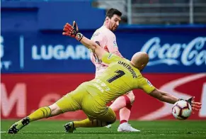  ?? — AP ?? Sublime: Barcelona’s Lionel Messi scoring past Eibar goalkeeper Marko Dmitrovic during the La Liga match in Eibar on Sunday.