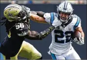  ??  ?? Panthers running back Christian Mccaffrey pushes away from Saints linebacker Demario Davis. Mccaffrey rushed for 72 yards and caught five passes for 65 yards.