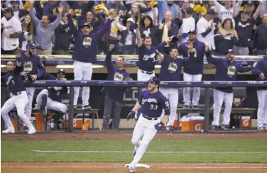  ?? Dylan Buell / Getty Images ?? Milwaukee reliever Brandon Woodruff rounds first after hitting a solo home run off Clayton Kershaw.