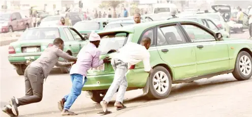  ?? Photo: Onyekachuk­wu Obi ?? Passengers assist driver push his car out of the road at Jabi Abuja yesterday