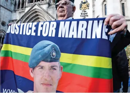  ??  ?? Support: One of the ex-Marines who gathered outside the Royal Courts of Justice yesterday