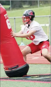  ??  ?? Junior defensive lineman Ryan Cude hits a tackling dummy during fall camp.