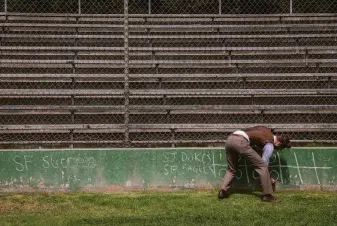  ?? ?? Nate Bennett, who is playing the role of a “sir” or umpire, writes the score in chalk as teams in the Bay Area Vintage Base Ball league play at Big Rec Ballfield in Golden Gate Park.