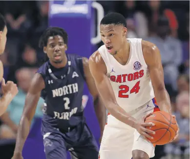  ?? MATT STAMEY/ASSOCIATED PRESS ?? Florida forward Kerry Blackshear Jr. looks to pass around North Florida forward Wajid Aminu during the second half Tuesday in Gainesvill­e, Fla. Blackshear was making his Gators debut after starring for Virginia Tech.