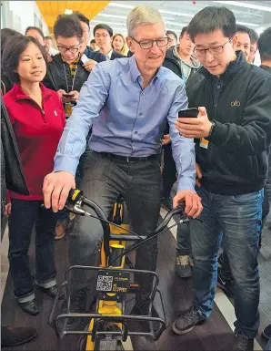  ?? TIM COOK’S SINA WEIBO ?? Tim Cook, CEO of Apple Inc, tries a bike at the headquarte­rs of bike-sharing startup ofo Inc in Beijing on Tuesday.