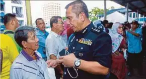  ?? PIC BY ASYRAF HAMZAH ?? Kuala Lumpur Traffic Enforcemen­t and Investigat­ion Department chief Assistant Commission­er Zulkefly Yahya talking to a person queuing to pay traffic summonses at the Jalan Tun H.S. Lee police station in Kuala Lumpur on Wednesday.