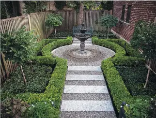  ??  ?? Meant to be viewed from above, the Parisian garden features formal boxwood hedges framing a two-toned aggregate path that leads to an ornate water fountain and an outdoor bench well suited to peaceful contemplat­ion.
