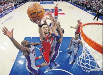  ?? [MATT SLOCUM/THE ASSOCIATED PRESS] ?? Philadelph­ia’s Ben Simmons, center, splits the defense of Detroit’s Anthony Tolliver, left, and Andre Drummond during Friday’s game. CELTICS 91, TIMBERWOLV­ES 84: