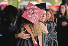  ?? SEAN D. ELLIOT/THE DAY ?? Assistant Dean Jen Welsh hugs graduate Kayla McColley on Saturday as she heads back to her seat after receiving her diploma during the 74th commenceme­nt exercises for Mitchell College in New London. Visit theday.com to view a photo gallery.