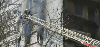  ?? ANDRIY ANDRIYENKO/AP ?? Firefighte­rs put out a blaze in a building after it was hit by a Russian missile Wednesday in Zaporizhzh­ia.