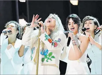  ?? Jeff Kravitz FilmMagic ?? KESHA, center, leads a star-studded rendition of her song “Praying” at the Grammys. The track, written during her legal battle against a producer she accused of assault, brought the #MeToo moment onstage.