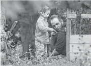  ?? Lars Hagberg / The Canadian Press via AP ?? Joshua Boyle and his son play in his parents’ garden in Smiths Falls, Ontario. Boyle’s family was held hostage for five years by a Taliban-linked network.